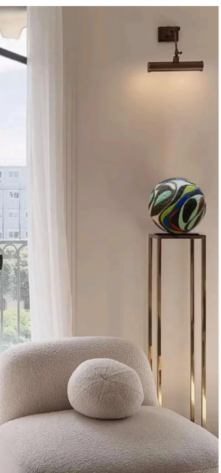 Un'Arca della serie in un ambiente domestico, su colonna in ottone.